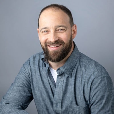 James Thole, smiling and wearing a casual blue shirt, showcasing personalized copywriting services for effective brand messaging.