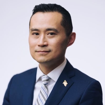 Professional portrait of a man in a navy suit and striped tie, conveying confidence and professionalism, relevant to testimonials about James Thole's impactful copywriting services.